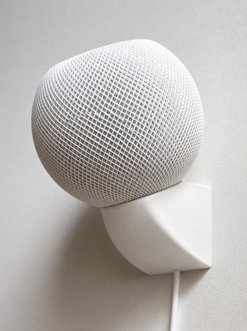 White HomePod mini installed on a matching white SPEKURA wall mount